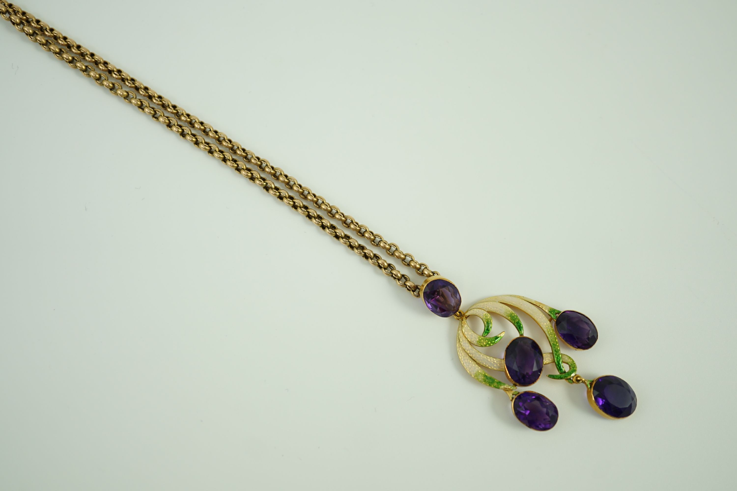 An early 20th century continental gold, enamel and five stone oval cut amethyst set drop pendant, of scrolling design